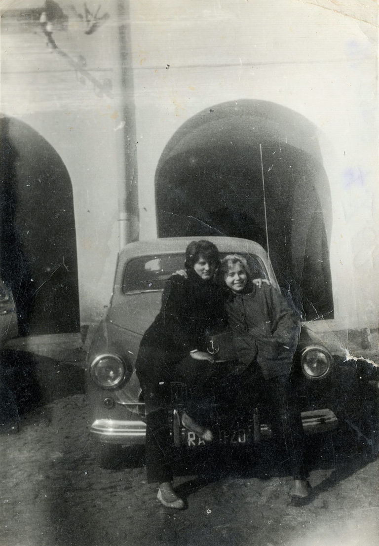 Pani Irena Miazga z przyjaciółką pozują do zdjęcia przed samochodem marki Warszawa.