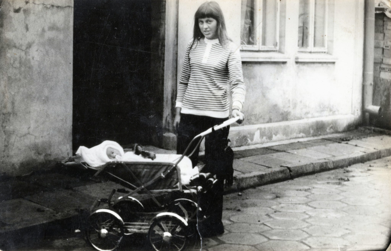 Pani M. Rudnicka (z d. Ładoś) wraz z córką pozuje do zdjęcia na tle jednego z domów przy ulicy Sienkiewicza w Głogowie.