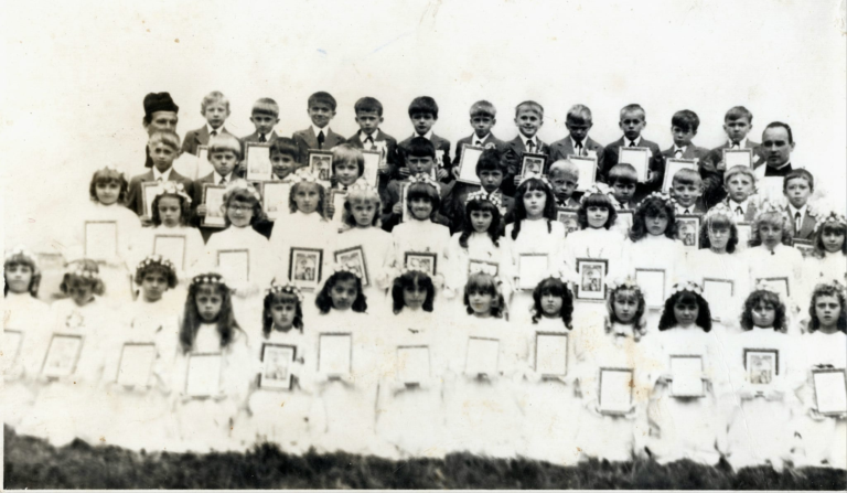 I Komunia Św. w Przewrotnem.Grupa dzieci pozuje do pamiątkowego zdjęcia z ks. Tadeuszem Bukałą.