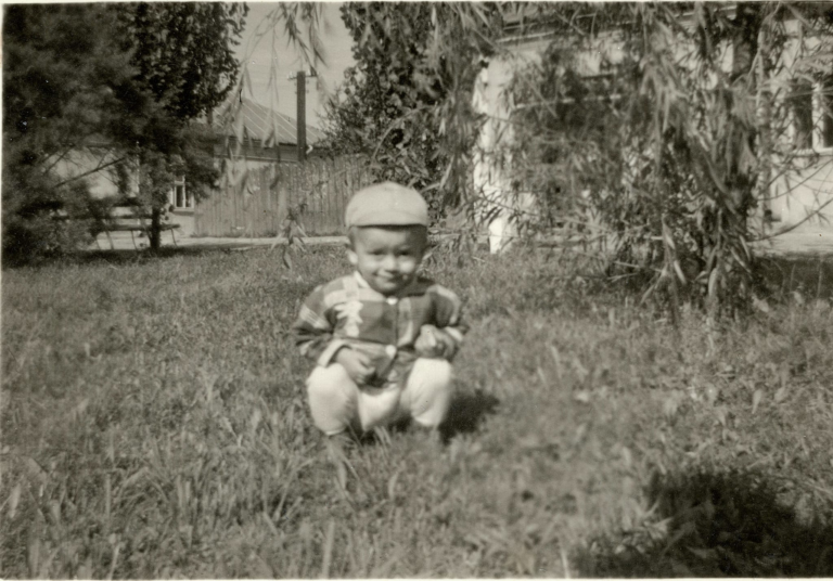 Pan Jacek Tarka pozuje do zdjęcia na plantach w Rynku. W tle od lewej widoczna jest kamienica nr 32