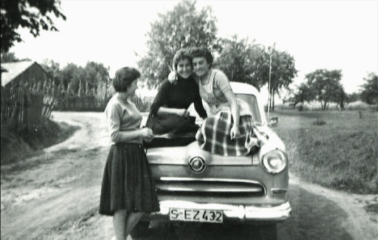 Panie : Maria Kosik , Bronisława Bazan i Kazimiera Reguła pozują do zdjęcia przy samochodzie na początku ulicy Partyzantów w Głogowie.