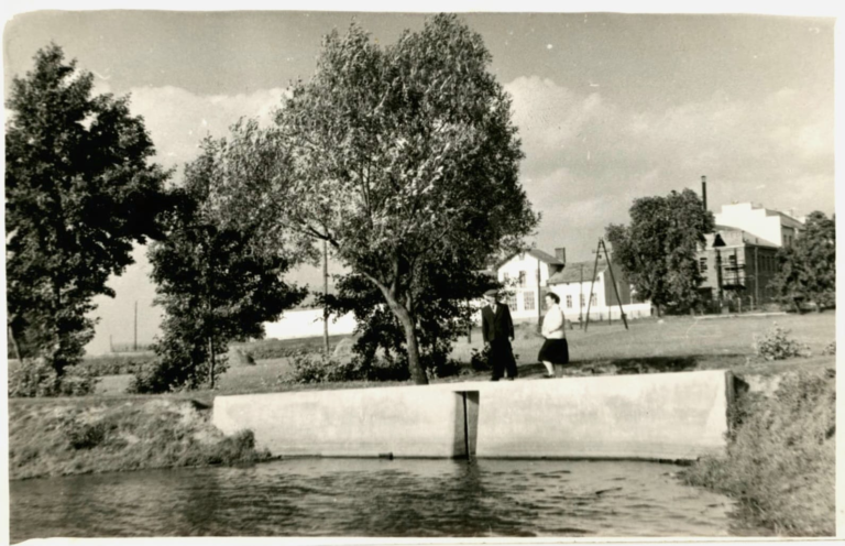 Kobieta i mężczyzna pozują do zdjęcia na tle upustu na Stawie Traczewskim.