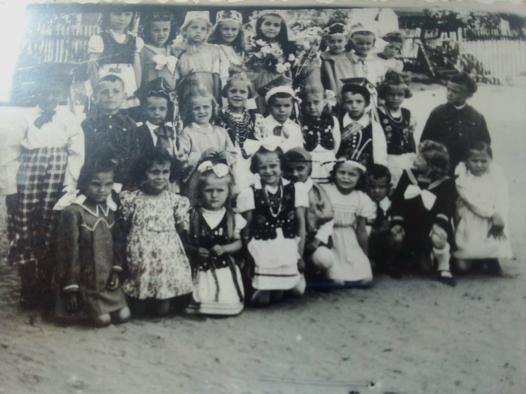 Dzieci z roczników 1943-1944 pozują do zdjęcia przed budynkiem ochronki w Głogowie..