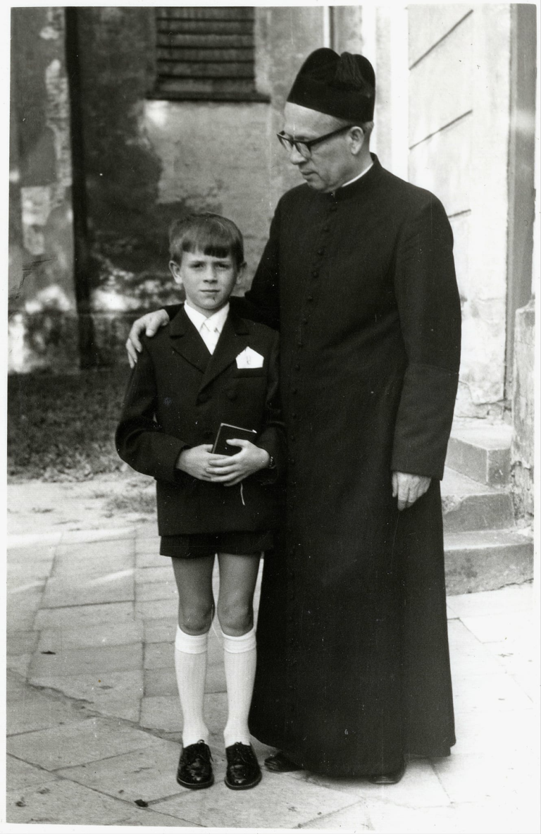 Pan Jacek Tarka z ks. Puzio pozują do zdjęcia pamiątkowego w tzw. „Białym Tygodniu” przed kościołem parafialnym w Głogowie.