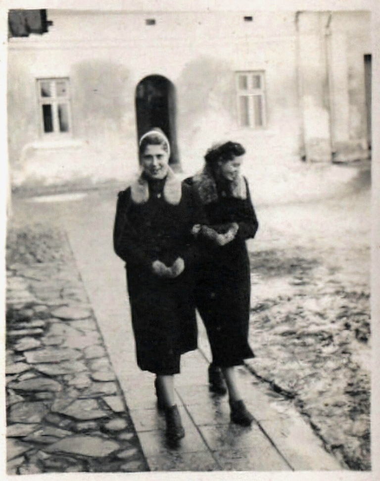 Dwie kobiety pozują do zdjęcia obok budynku banku w Głogowie. W tle „dom pod krzyżem” czyli Rynek 25.