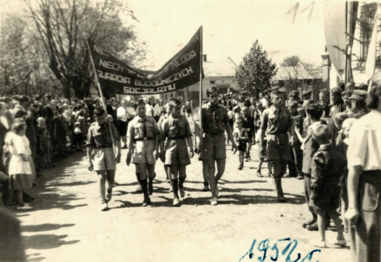 Pochód pierwszomajowy idzie ulicą obok ratusza w Głogowie.