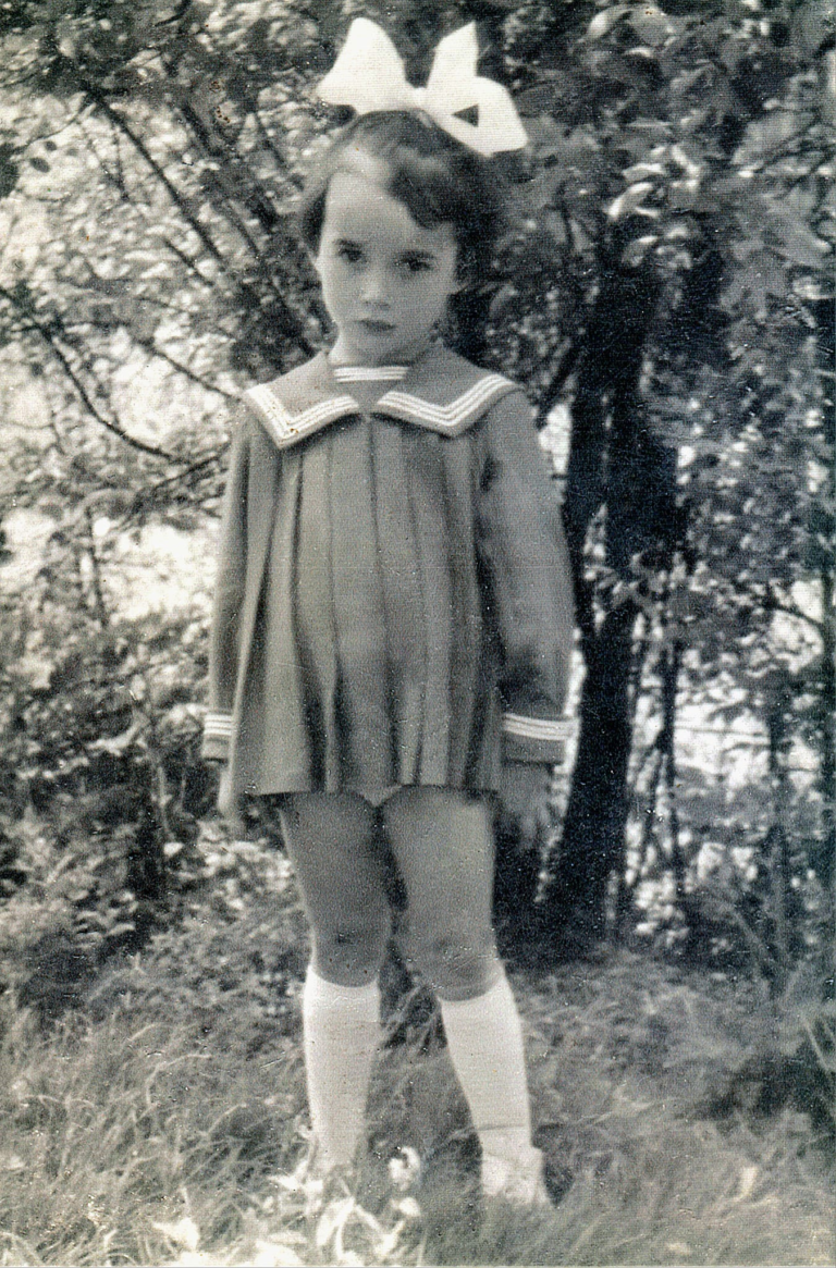 Pani Anna Bąk (z d. Wszoła) pozuje do zdjęcia w ogrodzie ówczesnego ośrodka zdrowia , który mieścił się przy ulicy 3-go Maja 1.