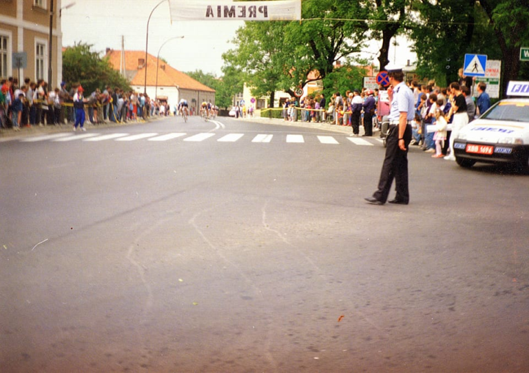 Zgromadzona obok ratusza publiczność dopinguje kolarzy podczas wyścigu kolarskiego , którego trasa wiodła także przez Głogów.
