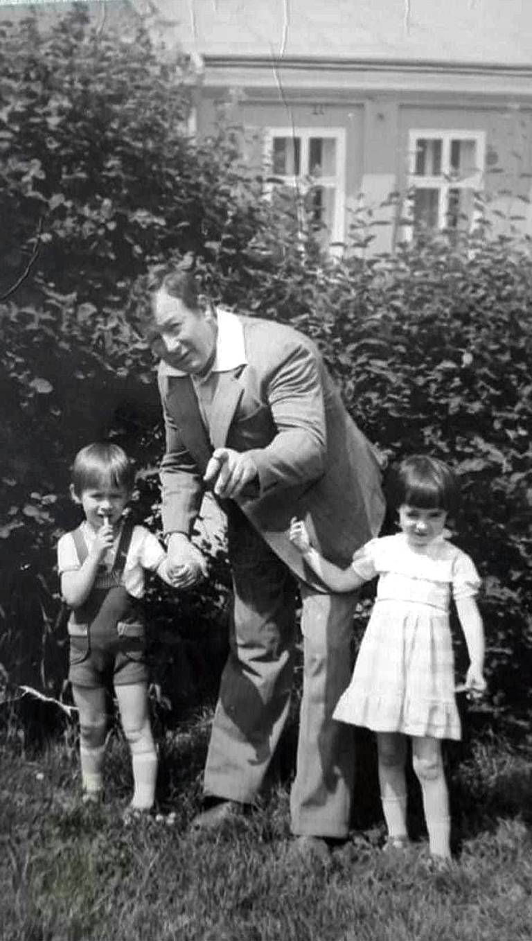 Pan Mieczysław Wszoła pozuje do zdjęcia razem z wnukami Ewą i Łukaszem na głogowskich plantach. W tle dom przy ulicy 11-go Listopada nr 1.