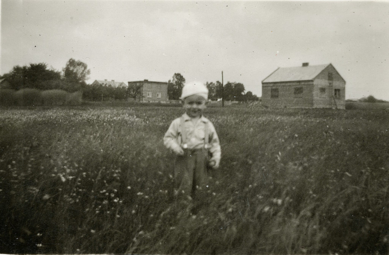 Pan Jacek Tarka pozuje do zdjęcia na łące pomiędzy ul. Larymowicza i Polną, na tyłach dawnego budynku weterynarii.