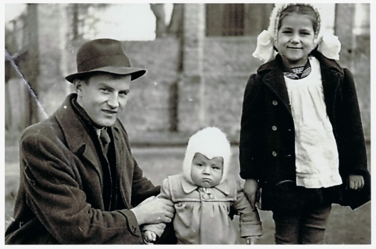 Józef Grodecki z córką Anną i synem Jackiem na ulicy Spytka Ligęzy , na tle ogrodzenia kościoła parafialnego w Głogowie.