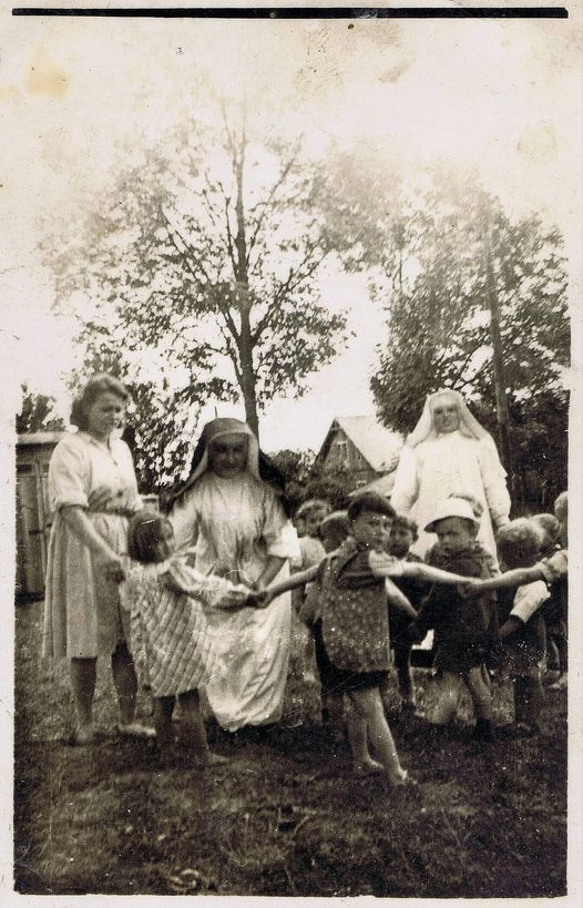 Grupa dzieci , pod opieką zakonnic , bawi się obok budynku ochronki w Głogowie. Jednym z dzieci jest śp. p. Ryszard Porada.